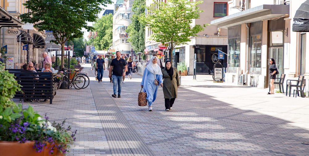 Gågata med människor i stadsmiljö.