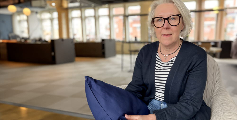 Kvinna i halvfigur med sovkudde i handen