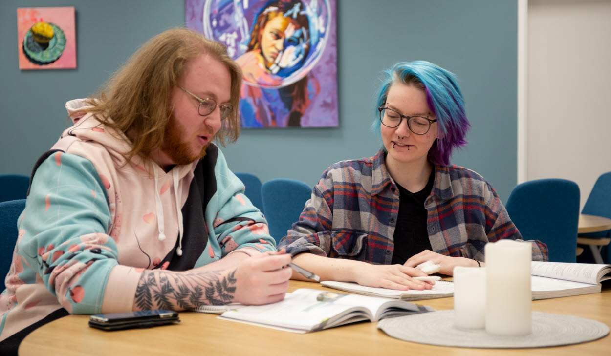 Två kursdeltagare sitter och studerar