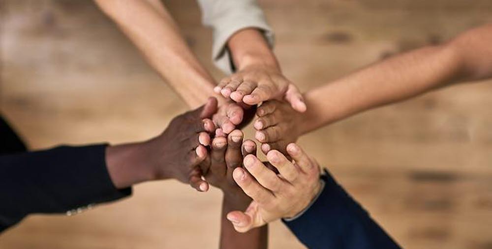 Händer på utsträckta armar som möts i mitten