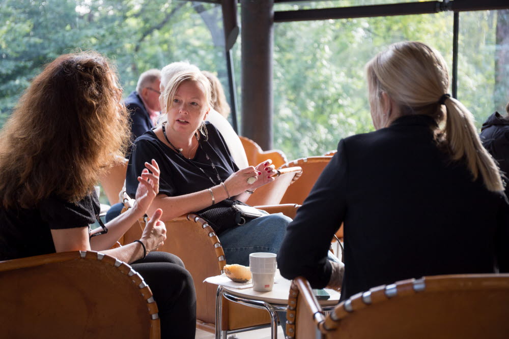 Tre personer i samtal vid ett bord.