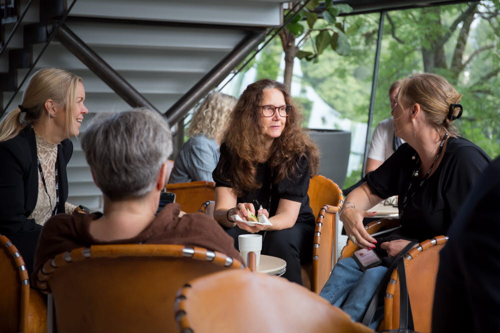 Fyra personer i samtal vid ett bord.